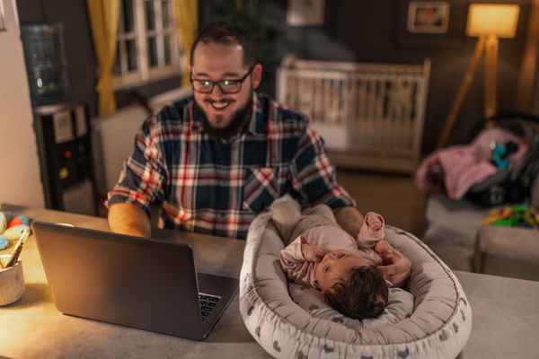Dad working on laptop with daughter