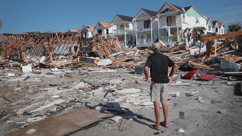 Man stands on flattened beach after Hurricane Michael