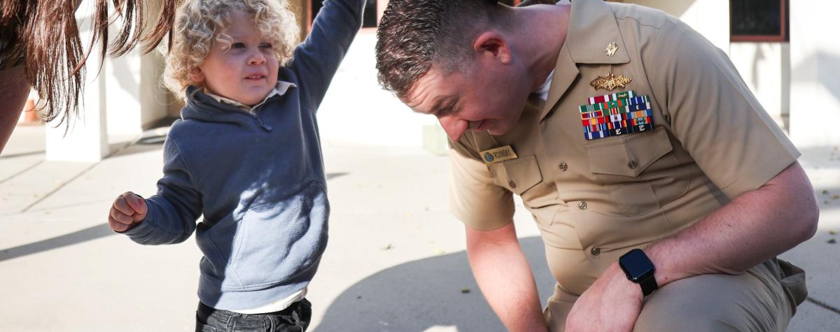 Son grabs fathers military hat off of his head