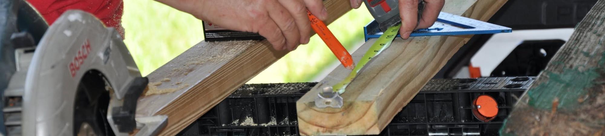 Volunteer cuts wood for Parker Day of Caring