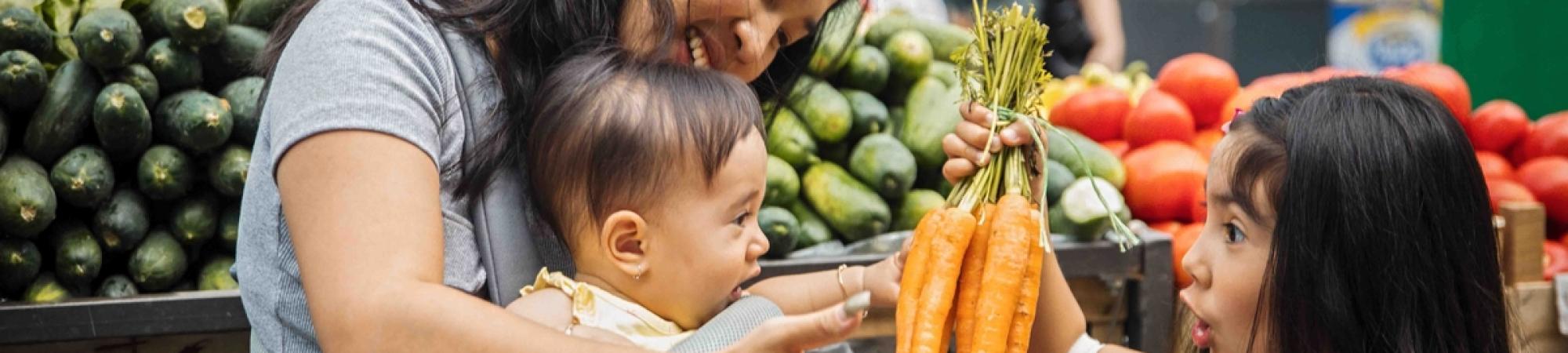 Mother and two kids getting fresh produce